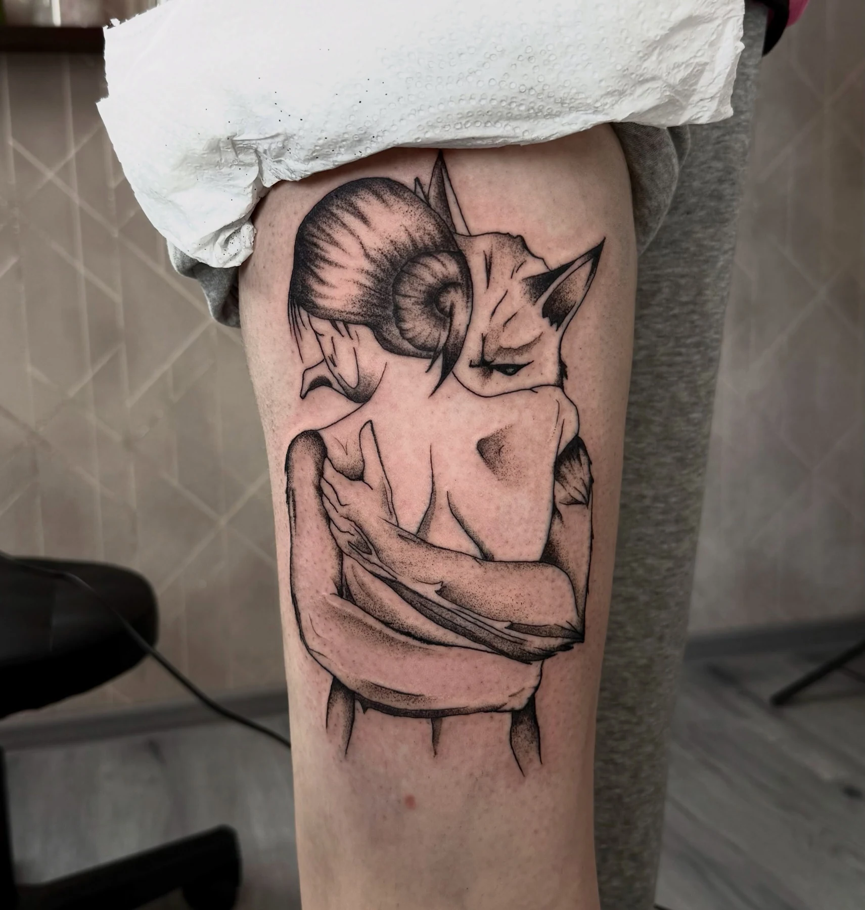 Чёрно-белая татуировка обнимающихся фигур с рогами